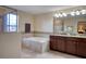 Bright bathroom with dual vanity, granite countertops, soaking tub, and separate glass shower at 19082 Umberland Pl, Land O Lakes, FL 34638