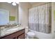 Bathroom with a shower-tub combo and a vanity with granite countertops and a decorative plant at 19082 Umberland Pl, Land O Lakes, FL 34638