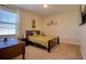 Cozy bedroom featuring a full bed, wooden desk, and bright natural light from the window at 19082 Umberland Pl, Land O Lakes, FL 34638
