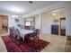 Elegant dining room featuring a large wooden table, seating for ten, and a decorative red rug at 19082 Umberland Pl, Land O Lakes, FL 34638