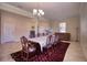 Dining room with long table, seating for ten, decorated with chandelier and tile floors at 19082 Umberland Pl, Land O Lakes, FL 34638