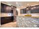 Kitchen with dark cabinets, stainless steel appliances, granite countertops and island with stone accents at 19082 Umberland Pl, Land O Lakes, FL 34638
