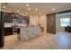 Open kitchen with dark cabinets, stainless steel appliances, a granite island, and a sliding barn door at 19082 Umberland Pl, Land O Lakes, FL 34638