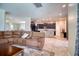 Open-concept living room showcasing a large sectional sofa, with kitchen and dining area in view at 19082 Umberland Pl, Land O Lakes, FL 34638