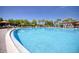 Resort-style swimming pool with lounge chairs, tables, and umbrellas on a sunny day at 19082 Umberland Pl, Land O Lakes, FL 34638
