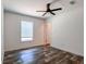 A bedroom features a modern ceiling fan, wood-look flooring, and a window at 20064 Manecke Rd, Brooksville, FL 34601