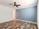 Bedroom featuring wood-look flooring, blue accent wall, and a window at 20064 Manecke Rd, Brooksville, FL 34601