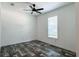 Bedroom with modern ceiling fan, window with blinds, and gray wood-look flooring at 20064 Manecke Rd, Brooksville, FL 34601