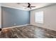 Bedroom featuring wood-look flooring, blue accent wall, and a window at 20064 Manecke Rd, Brooksville, FL 34601