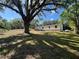 A beautiful home with a landscaped yard, a gorgeous tree, and a sunny blue sky at 20064 Manecke Rd, Brooksville, FL 34601