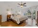 Bright bedroom featuring modern decor, sliding glass doors to balcony, hardwood floors, and a ceiling fan at 2026 Golfview Dr # 2026, Tarpon Springs, FL 34689