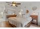 Bright main bedroom with accent mirrors, hardwood flooring, a wooden bed frame, and soft natural lighting at 2026 Golfview Dr # 2026, Tarpon Springs, FL 34689