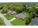 Aerial view of the home with a well-maintained lawn, pool, mature trees, and lush landscaping, highlighting its serene setting at 2122 Meadow Lark Rd, Spring Hill, FL 34608