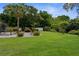 Well-maintained backyard with a beautiful lawn, landscaping, and mature trees, creating a serene and inviting outdoor space at 2122 Meadow Lark Rd, Spring Hill, FL 34608