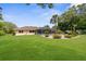 Beautiful backyard with a screened-in pool, lush lawn, mature trees and landscaping, creating an ideal setting for outdoor relaxation at 2122 Meadow Lark Rd, Spring Hill, FL 34608