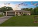 Charming home featuring well-manicured lawn, two-car garage, and mature trees, creating a warm and inviting curb appeal at dusk at 2122 Meadow Lark Rd, Spring Hill, FL 34608