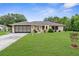 Charming home with a well-manicured lawn, two-car garage, and mature trees, offering a warm and inviting curb appeal at 2122 Meadow Lark Rd, Spring Hill, FL 34608