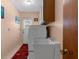 Functional laundry room with appliances, sink, storage and exterior access to yard at 2122 Meadow Lark Rd, Spring Hill, FL 34608
