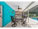 Covered outdoor patio area with ceiling fan and glass top table overlooking pool area at 2122 Meadow Lark Rd, Spring Hill, FL 34608