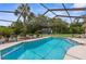 Relaxing backyard pool with lush green landscape and a secluded shed in the distance at 2122 Meadow Lark Rd, Spring Hill, FL 34608
