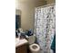 Cozy bathroom featuring vanity, a toilet and shower/tub combination adorned with a playful butterfly shower curtain at 2850 Westmoreland Ct, New Port Richey, FL 34655