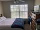 Bright bedroom with a large window allowing plenty of natural light, complemented by comfortable furnishings at 2850 Westmoreland Ct, New Port Richey, FL 34655