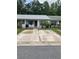 Charming townhome featuring a light gray roof, gray shutters, and a concrete parking pad at 2850 Westmoreland Ct, New Port Richey, FL 34655