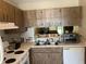 Traditional kitchen features a double sink, white appliances, and generous counter space, perfect for meal preparation at 2850 Westmoreland Ct, New Port Richey, FL 34655