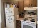A cozy kitchen features white appliances, and ample cabinet space above the stove and refrigerator at 2850 Westmoreland Ct, New Port Richey, FL 34655