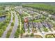 Aerial view featuring a home in a neighborhood near a road, a lake, and a wooded area at 3056 Abrams Trl, Odessa, FL 33556