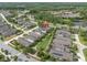 Aerial view displays the home in a neighborhood near a road, pond, wooded area, and other homes at 3056 Abrams Trl, Odessa, FL 33556