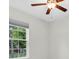 Bright bedroom featuring a ceiling fan, a window with natural light and views of the outside greenery at 3056 Abrams Trl, Odessa, FL 33556