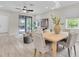 Bright dining area with light wood tile flooring, comfortable seating, and modern light fixture at 3056 Abrams Trl, Odessa, FL 33556