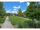 A beautifully landscaped front yard with lush green grass, a sidewalk, and mature trees at 3056 Abrams Trl, Odessa, FL 33556