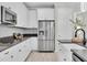 Modern kitchen with stainless steel refrigerator, white cabinets, and gray countertop at 3056 Abrams Trl, Odessa, FL 33556