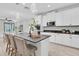 Bright, modern kitchen featuring white cabinets, gray countertops, and a central island with seating at 3056 Abrams Trl, Odessa, FL 33556