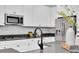 Close-up of kitchen featuring white cabinets, stainless steel microwave, and gray backsplash at 3056 Abrams Trl, Odessa, FL 33556