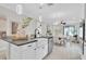 Open-concept kitchen island with sink, white cabinets, and view of dining area at 3056 Abrams Trl, Odessa, FL 33556