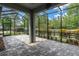 Screened in patio features plenty of open space, a decorative fan, and views of the surrounding greenery at 3056 Abrams Trl, Odessa, FL 33556