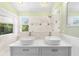 Bathroom featuring double sinks, decorative tile, and a walk-in shower at 3119 Oyster Bayou Way, Clearwater, FL 33759
