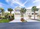 Three-story townhome featuring a two car garage, palm trees, and manicured landscaping at 3119 Oyster Bayou Way, Clearwater, FL 33759