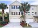 Inviting three-story townhouse with a two-car garage and mature landscaping with palm trees at 3119 Oyster Bayou Way, Clearwater, FL 33759