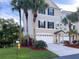 Charming three-story townhouse featuring a two-car garage, tropical landscaping, and a well-maintained lawn at 3119 Oyster Bayou Way, Clearwater, FL 33759