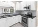 Updated kitchen featuring stainless steel appliances, granite countertops, and modern white cabinetry at 3119 Oyster Bayou Way, Clearwater, FL 33759