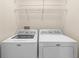 Functional laundry area with a washing machine and dryer, plus overhead wire shelving at 3119 Oyster Bayou Way, Clearwater, FL 33759