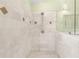 Frameless glass walk-in shower featuring marble tile and decorative accents at 3119 Oyster Bayou Way, Clearwater, FL 33759