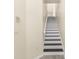 White staircase with dark wood steps leading to the upper level of the home at 3119 Oyster Bayou Way, Clearwater, FL 33759