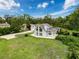 Aerial view of the beautiful house on a manicured green lawn with a detached garage and mature trees at 31726 Sylvian Ln, Dade City, FL 33525