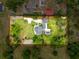 Aerial view of the property showcasing the home, landscaping, pool, driveway, and perimeter at 31726 Sylvian Ln, Dade City, FL 33525