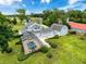 Beautiful aerial view of a home with a screened pool, lush landscaping, and a detached garage at 31726 Sylvian Ln, Dade City, FL 33525